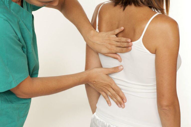 Der Arzt untersucht den Rücken mit Schmerzen unter dem linken Schulterblatt